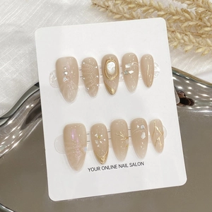 Handmade nude cat-eye press-on nails with 3D floral and pearl accents on display