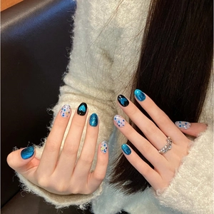 Cat-Eye-Kunstnägel zum Aufkleben im blauen Herz-Design mit ovaler Form an der Hand des Models