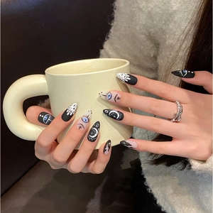 Handmade press-on nails with celestial moon and eye designs in a long almond shape
