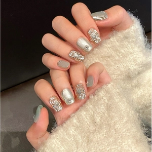 Unghie finte argento cat eye con texture metallica e strass applicate sulla mano