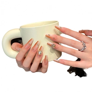 Faux ongles dégradés roses forme trapèze avec strass brillants sur tasse blanche