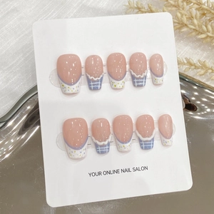 Faux ongles faits main avec motif écossais mauve et pois blancs sur base rose nude