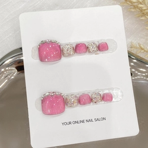 Handmade sparkly pink press-on toenails with rhinestone and pearl accents in a set of ten