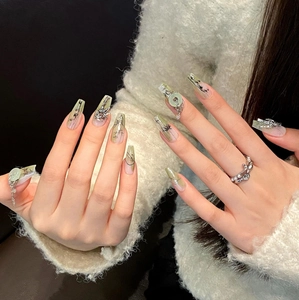 Macro shot of long coffin nails with hand-painted bamboo and jade ring charms