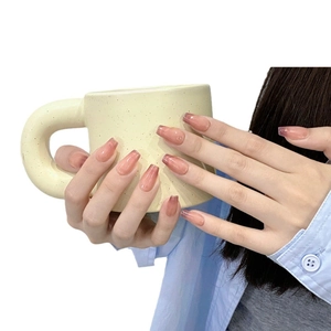 Faux ongles œil-de-chat dégradé rose de forme cercueil moyenne présentés sur main