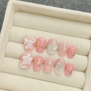 Pink press-on nails with 3D embossed flowers, pearls, and glitter in a velvet display box
