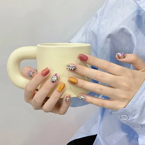 Handmade press-on nails with red cat eye effect and hand-painted white daisies