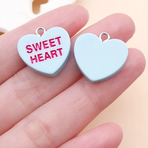 Macro detail of 19mm matte light blue heart pendant with Sweet Heart text and metal ring