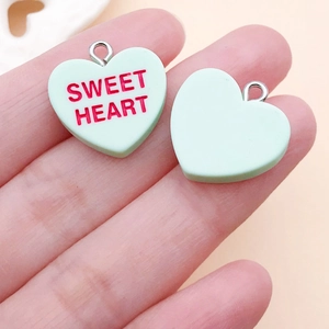Macro shot of mint green Sweet Heart pendant with silver ring and smooth back side