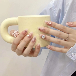 Pink gradient press-on nails with rhinestone bow and heart patterns in long trapezoid shape