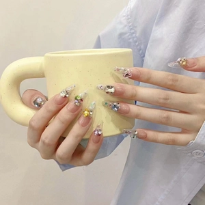 Handmade press-on nails with colorful rhinestones and sparkling glitter in almond shape