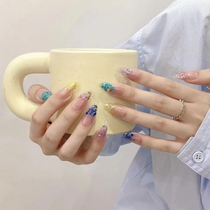 Sparkling blue gradient mermaid style press-on nails with sequins on a long almond shape