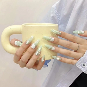 Hand-painted green and white long coffin press-on nails with artistic leaf pattern