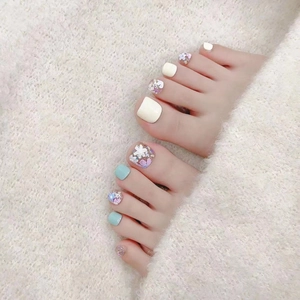 Handmade press-on toenails featuring yellow and blue matte finishes with floral glitter