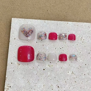 Faux ongles rouges et crème faits main avec cœur pailleté et fini brillant chic