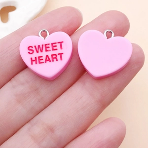 Close-up of pink heart charms with red Sweet Heart text and silver metal loops