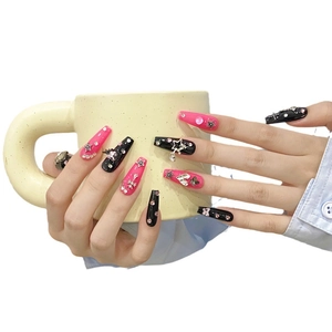 Pink and black coffin press-on nails with 3D rhinestones and metal charms on hand