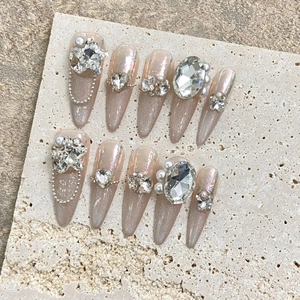 Handmade almond cat-eye press-on nails with sparkling rhinestones and pearls on stone