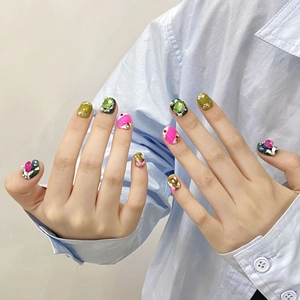 Handmade press-on nails with colorful rhinestones and 3D floral art on blue background
