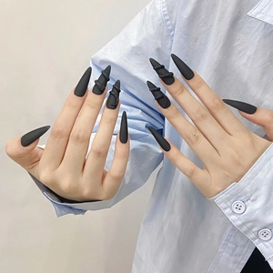 Matte black press-on nails featuring 3D snake design in a long stiletto shape