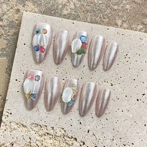Handmade almond press-on nails with lavender pearl finish and shell stone accents