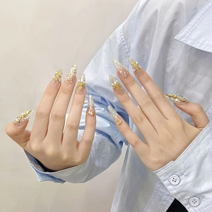 Handmade long almond press-on nails with gold foil, floral 3D relief, and shimmering gems
