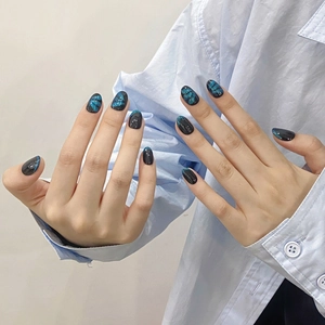 Dark blue and black cat-eye press-on nails with handmade glitter and oval shape design