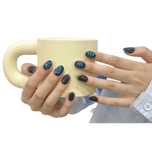 Handmade press-on nails featuring dark blue cat eye glitter and elegant black bow accents