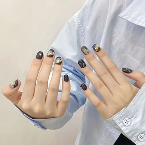 Handmade galaxy press-on nails with blue marble texture and gold foil glitter design