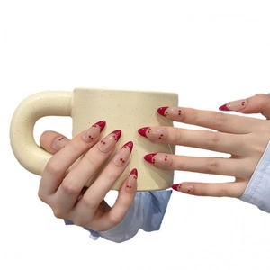 Handgefertigte Mandel-Kunstnägel mit roten French Tips und handgemalten Kirsch-Designs