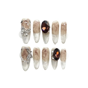 Handmade amber cat eye press-on nails with silver glitter and 3D butterfly charms