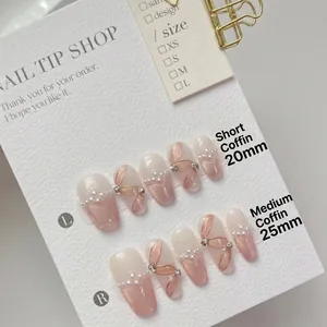 Pink cat eye handmade press-on nails with pearls and ribbon design in coffin shape