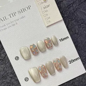 Cat eye press-on nails in champagne gold with sparkling rhinestones and glitter