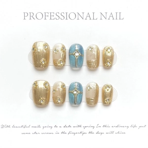 Handmade champagne gold and star-blue press-on nails with luxury metal texture and gems