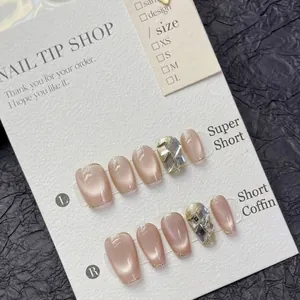 Roze cat eye kunstnagels met gouden randjes en diamantjes op een zwarte achtergrond