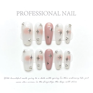 Detail of pink and white gradient press-on nails with silver star and rhinestone accents