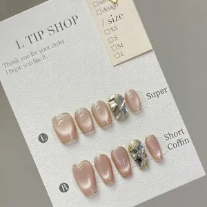Roze cat eye kunstnagels met luxe zilveren strass-steentjes en gouden randaccent