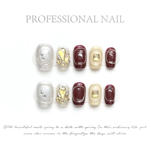 Detail of handmade press-on nails featuring burgundy, cream white, and silver glitter finishes
