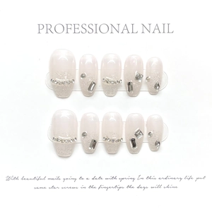 Detailed view of handmade pink press-on nails with silver glitter and luxury rhinestones