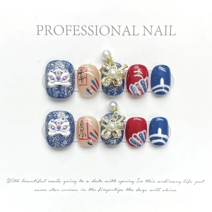 Detail of 3D lion dance press-on nails with peace and joy calligraphy and pearls