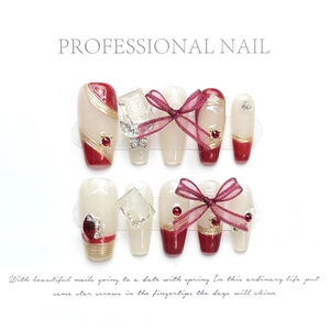 Detailed set of 10 handmade press-on nails featuring red bows and crystal accents
