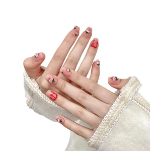 Handmade strawberry press-on nails in nude pink featuring artistic red splash designs