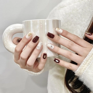 Handmade burgundy and cream press-on nails with floral art, gold foil, and rhinestones