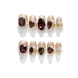 Faux ongles faits main amande avec cristaux ambrés, perles et nœuds argentés de luxe