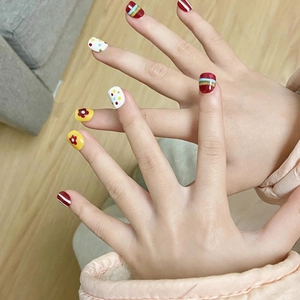 Cute children's press-on nails featuring colorful rainbow patterns and floral designs
