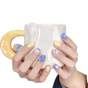 Handmade short round press-on nails with blue yellow floral patterns and polka dots