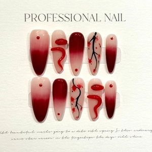 Detail of handmade press-on nails featuring red 3D snake charms and plum blossom motifs