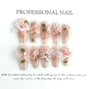 Detail of handmade coffin press-on nails with 3D roses, lace bows, and pearls
