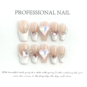 Macro detail of handmade press-on nails featuring French white tips, 3D hearts and pearls