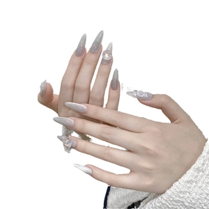 Faux ongles stiletto faits main avec dégradé gris-blanc, paillettes argentées et strass papillon